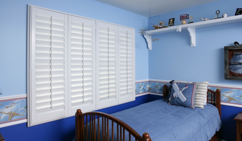 White plantation shutters in blue kids bedroom in San Diego 